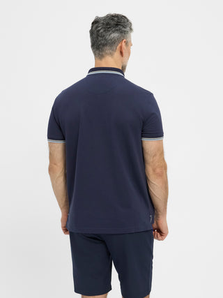 Navy kortærmet polo fra Redgreen i 100 % bomuld med kontraststribet krave og ærmekant samt lille sejlskibslogo.