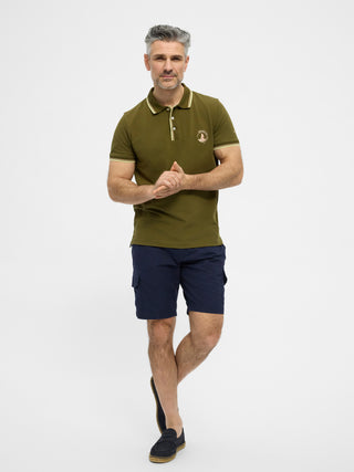 Olivengrøn kortærmet polo fra Redgreen i 100 % bomuld med kontraststribet krave og ærmekant samt lille sejlskibslogo.